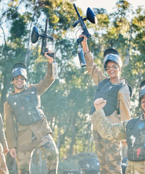 Team, paintball and portrait in celebration for winning, victory or achievement on the battlefield